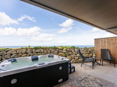 An outdoor area with a hot tub and chairs at tbc in St. Ives