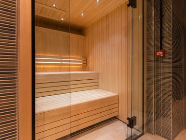 A sauna with wooden benches and glass door at Hidden 2-Bay House Hot Tub St Ives