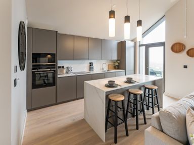 A kitchen with counter stools and appliances at tbc in St. Ives