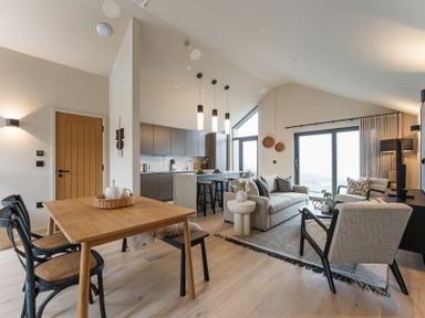 A living room and kitchen area with furniture at tbc in St. Ives