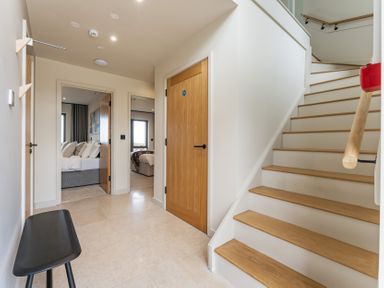 A hallway with stairs and a door at tbc St. Ives