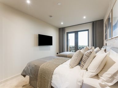 A bedroom with two beds and a television at tbc in St. Ives
