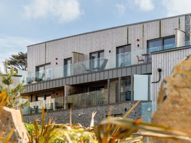 A building with balconies and outdoor furniture at Hidden 3- Sea Terrace House St Ives