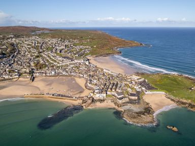 An aerial view of a coastal town and beach with boats at Hidden 3- Sea Terrace House in St Ives