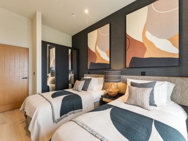 A bedroom with two single beds and artwork on the wall at tbc in St. Ives