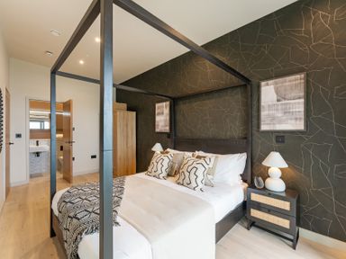 A bedroom with a four-poster bed and bedside table at tbc in St. Ives