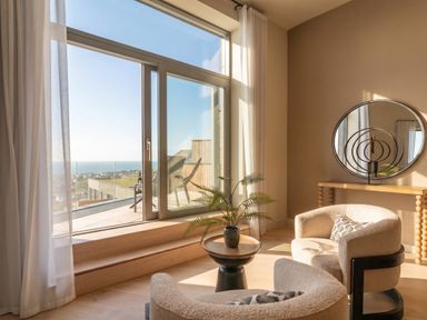 A living room with a window and chairs at Hidden 9 – Grand Bay Suite Hot Tub St Ive