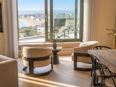A living room with a window and chairs at Hidden 9 – Grand Bay Suite Hot Tub in St Ive