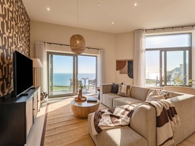 A living room with a sofa and coffee table at Hidden 9 – Grand Bay Suite Hot Tub in St Ive