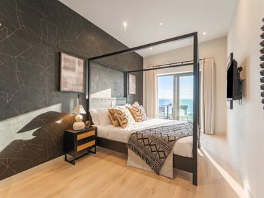 A bedroom with a bed and television at Hidden 9 – Grand Bay Suite Hot Tub St Ive