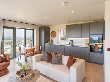 A living room with a kitchen area and dining table at tbc in St. Ives