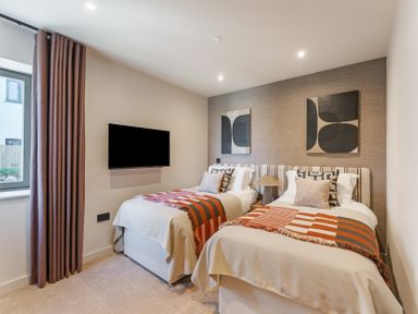 A bedroom with two beds and a television at tbc in St. Ives