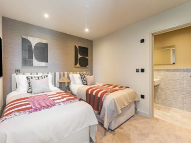A bedroom with two beds and wall art at tbc in St. Ives