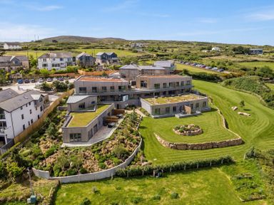 A view of a property surrounded by lawns and landscaping at Hidden 18- St Ives Bay Suite Hot Tub in St Ives