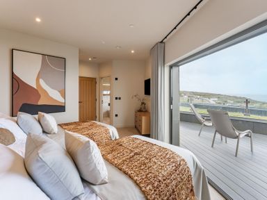 A bedroom with two beds and a sliding door at tbc in St. Ives