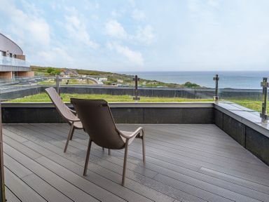 An outdoor area with chairs and a view at The Old Barn in St. Ives