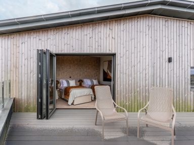 A patio with two chairs and an open door leading to a bedroom at tbc St. Ives