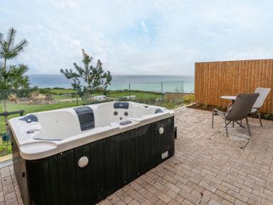 An outdoor area with a hot tub and chair at tbc in St. Ives