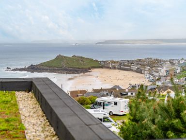 A beach with houses and a campervan at tbc in St. Ives