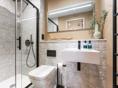 A bathroom with a shower, toilet, and sink at Hidden 19- Coastal Hot Tub in St Ives