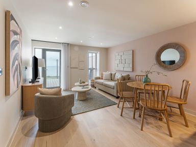 A living room with a sofa and dining area at tbc in St. Ives