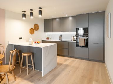 A kitchen with bar counter and stools at The Old Barn in St. Ives