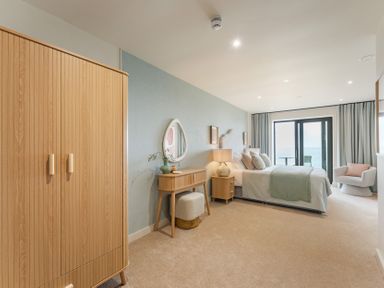 A bedroom with a bed, wardrobe, and balcony doors at tbc in St. Ives