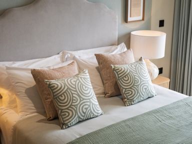 A bedroom with two decorative pillows and a lamp at tbc in St. Ives