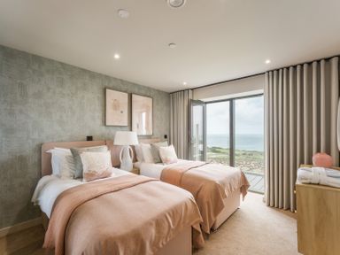 A bedroom with two beds in front of a large window at tbc in St. Ives