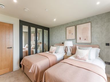 A bedroom with twin beds and a wardrobe at tbc in St. Ives