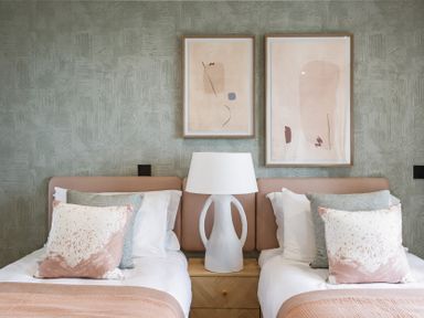 A bedroom with two beds and artwork on the wall at tbc in St. Ives