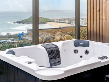A hot tub with a view overlooking the beach at tbc in St. Ives