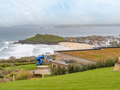 A view of the beach and ocean with a playground at tbc St. Ives