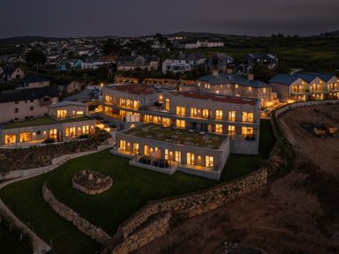 An outdoor view of illuminated buildings at Hidden 20- Gallery Hot Tub in St Ives