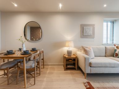 A living room with a dining table and sofa at tbc St. Ives