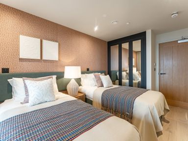 A bedroom with two beds and a wardrobe at tbc in St. Ives