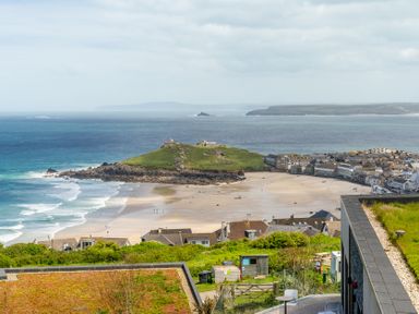 A view of a beach with houses and a hill at Hidden 10- Godrevy View, St Ives