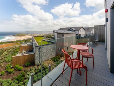 An outdoor area with a deck and chairs at Hidden 10- Godrevy View St Ives