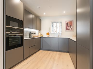 A kitchen with an oven, microwave, and kitchen cabinets at Hidden 10- Godrevy View in St Ives