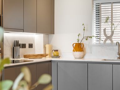 A kitchen with modern cabinets and a vase on the countertop at Hidden 10- Godrevy View St Ives