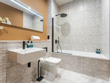A bathroom with a bathtub and sink at Hidden 10- Godrevy View in St Ives