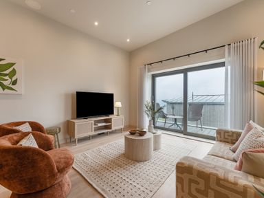 A living room with a television and seating at tbc in St. Ives