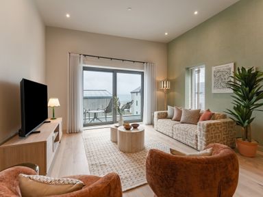 A living room with a television, sofa, and coffee table at tbc in St. Ives