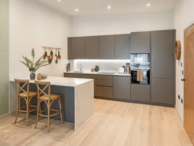 A kitchen with a counter and bar stools at tbc in St. Ives