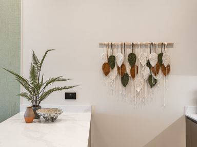 A kitchen with a wall decoration and a plant at tbc in St. Ives