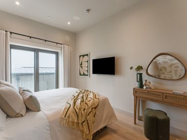 A bedroom with a bed and television at tbc in St. Ives