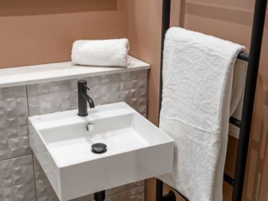 A sink with towels on a rack at tbc in St. Ives