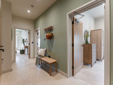A hallway with a bench and access to rooms at tbc in St. Ives