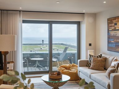 A living room with a sofa and a view of the sea at tbc in St. Ives