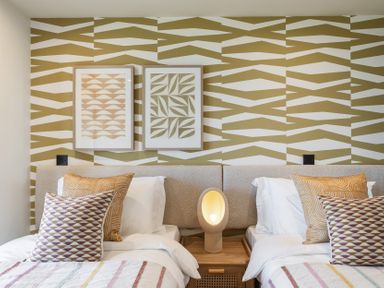 A bedroom with two beds and wall art at tbc in St. Ives